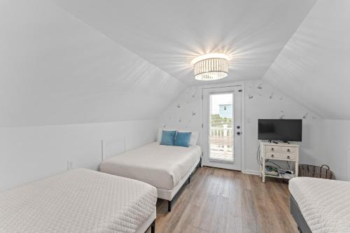 a bedroom with two beds and a tv and a window at Ft Morgan Bama Belle-Beach Access in Gulf Shores