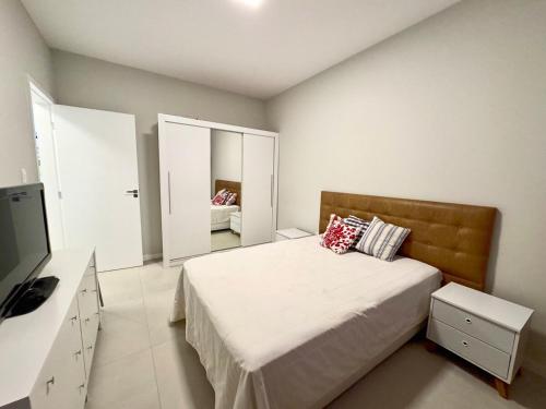 ein Schlafzimmer mit einem Bett, einer Kommode und einem TV in der Unterkunft Apartamento no Centro - conforto e praticidade in Florianópolis
