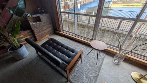 a living room with a couch and a large window at hotorino in Numazu