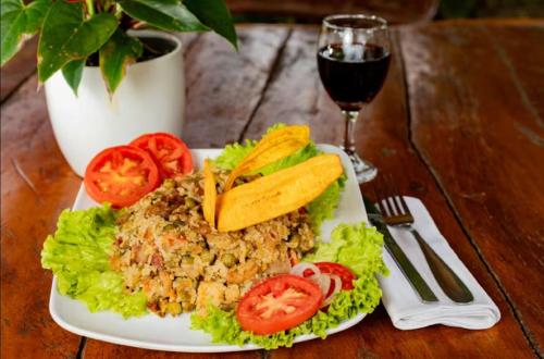 a plate of food on a table with a glass of wine at Condado de Casa Grande in San Gil