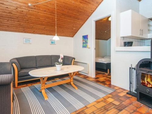 a living room with a couch and a table and a fireplace at 10 person holiday home in Glesborg-By Traum in Glesborg