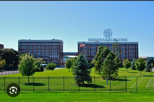 a park with trees and buildings in the background at 3 bedroom 1 bathroom apartment , free private parking in Schenectady