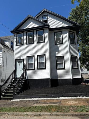 a white house with a staircase in front of it at 3 bedroom 1 bathroom apartment , free private parking in Schenectady