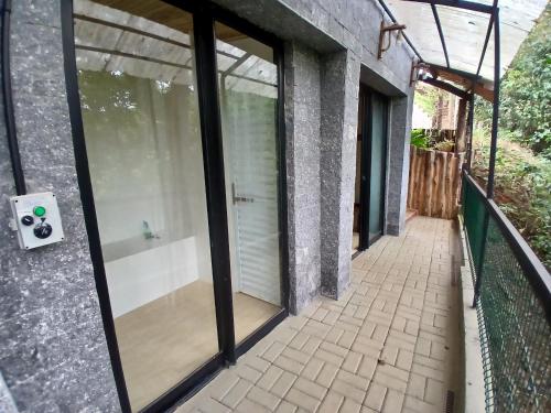 a glass door on a building with a walkway at Chalé Ecos do Jucu sauna-ofurô-piscina aquecida-wifi in Domingos Martins