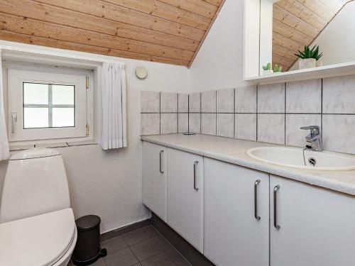 Un baño con lavabo, inodoro y ventana. en 12 person holiday home in Væggerløse-By Traum, en Bøtø By