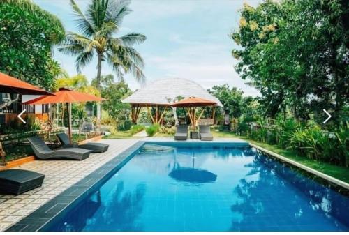 a swimming pool with a gazebo and a resort at Tinggian Hill Retreat in Nusa Penida
