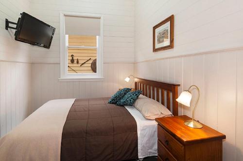 1 dormitorio con 1 cama y TV en la pared en Royal Hotel Snake Valley, en Snake Valley