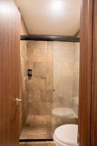 a bathroom with a toilet and a shower at Apartamento Anuva con Parking, Alberca y SkyView in Guadalajara