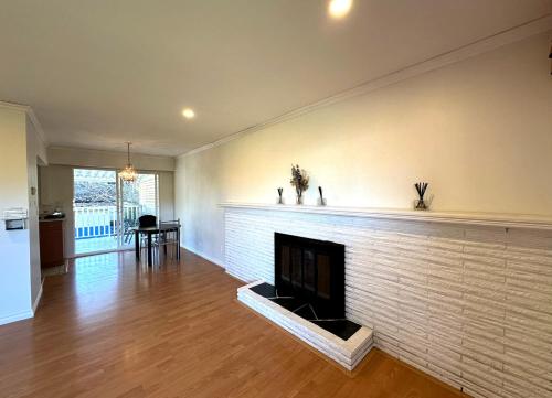 a living room with a white brick fireplace at Beautiful Place with Kitchen, Washing Machine and Internet Near YVR Airport, Transit and Shopping Mall in Richmond