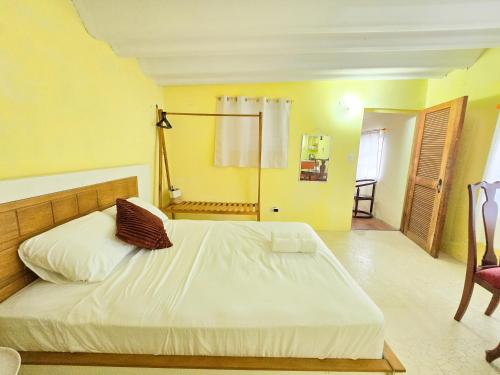 a bedroom with a large white bed and a chair at Dulce Vida - Casa con piscina a 200 mts de la Playa Punta Chame in Punta Chame