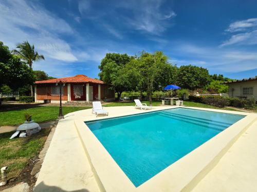 a swimming pool with two chairs and a house at Dulce Vida - Casa con piscina a 200 mts de la Playa Punta Chame in Punta Chame
