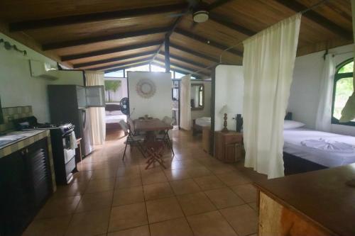 a room with a kitchen and a bedroom with a bed at spirit of jungle lodge in Sámara