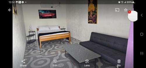 a living room with a couch and a bed at Bermuda Beach Aquatica in Daanbantayan