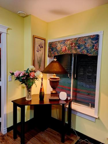 a room with a table with a vase of flowers and a window at Villa Bellissimo FranTalia in Kelowna