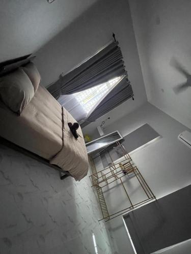 a bedroom with a bed with a window and a cage at D Raihan Guest House in Ketereh
