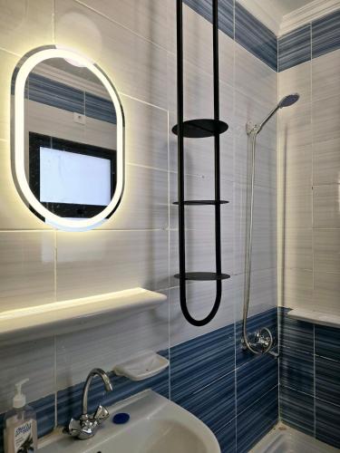 a bathroom with a shower with a sink and a mirror at Artistic, Cozy and bright in Madinaty