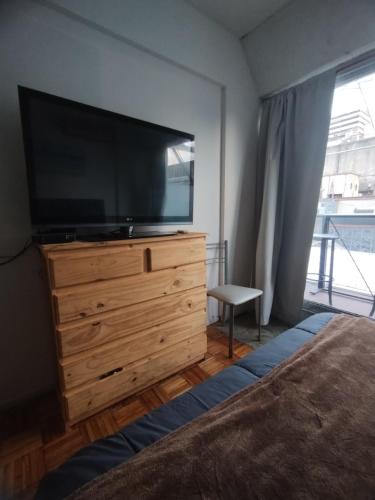 a bedroom with a flat screen tv on a dresser at Central y Comodo Departamento in Buenos Aires