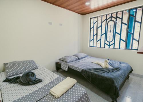two beds in a room with a stained glass window at Rancho Buenavista in Vergara