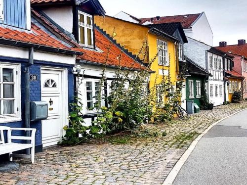 a cobblestone street with houses and a bench at GreenBrook Homes in Aalborg