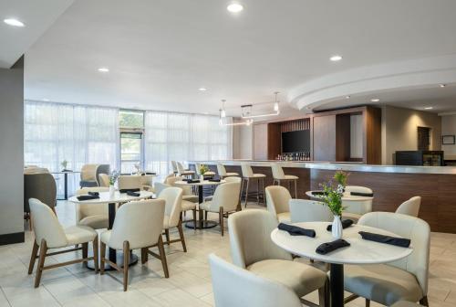 a restaurant with tables and chairs and a bar at Holiday Inn Boise Airport by IHG in Boise