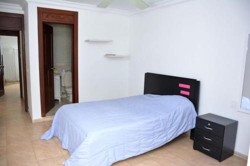 a bedroom with a bed and a dresser and a bathroom at Casa Cristales Oeste de Cali in Cali