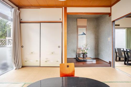 a living room with a table and a chair at Small House Near Narita Airport in Shisui