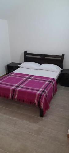 a bed with a purple blanket on top of it at Hotel Gran central armenia in Armenia