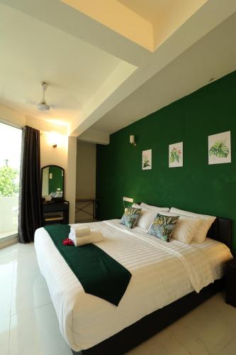 a large bed in a bedroom with a green wall at Pamera Thoddoo in Thoddoo