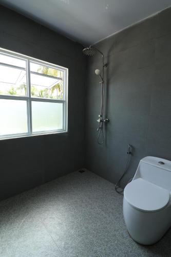 a bathroom with a toilet and a window at Pamera Thoddoo in Thoddoo