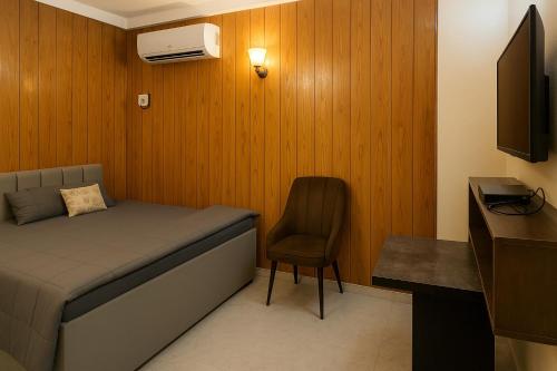 a small bedroom with a bed and a chair at Residence inn in Dīgha