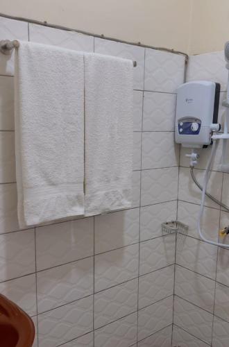 a bathroom with white towels hanging on a wall at Moods Holiday Homes in Kampala