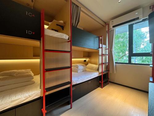 a room with two bunk beds and a window at Amic Girls' Hostel (Shenzhen Shekou Sea World) in Shenzhen