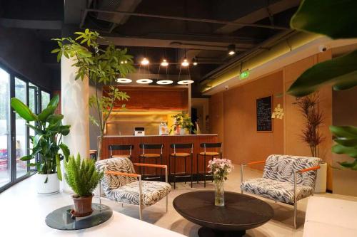 a lobby with chairs and a table and a bar at Amic Girls' Hostel (Shenzhen Shekou Sea World) in Shenzhen