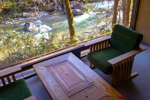 a room with a window with a chair and a table at Wanosato in Takayama