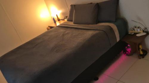 a bedroom with a large bed with a pink light at DAINTREE RAINFOREST Private ROOM w-Ensuite In my 2 bdroom home in Cow Bay