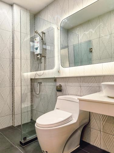 a bathroom with a toilet and a sink and a mirror at Laksika Place Khao Rang in Phuket