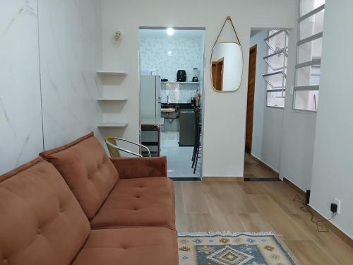 a living room with a brown couch and a kitchen at Apartamento térreo in Vitória