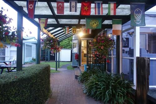 a building with flags and plants in front of it at Rotorua Hostel in Rotorua