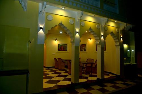 a dining room with a table and a checkered floor at Toshina Haveli in Jaipur