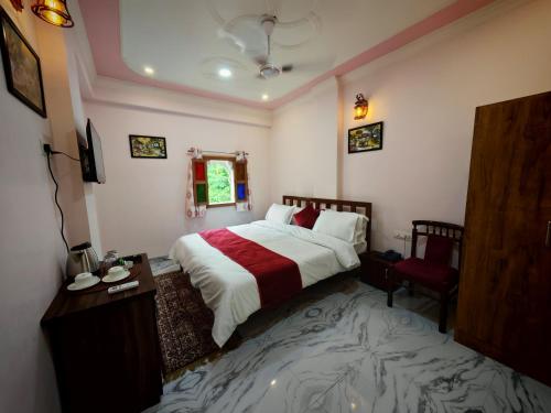 a bedroom with a large bed and a red chair at Toshina Haveli in Jaipur