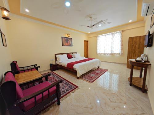 a bedroom with a bed and a couch and a table at Toshina Haveli in Jaipur