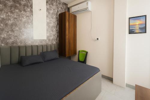 a small bedroom with a bed and a green chair at Residence inn in Dīgha