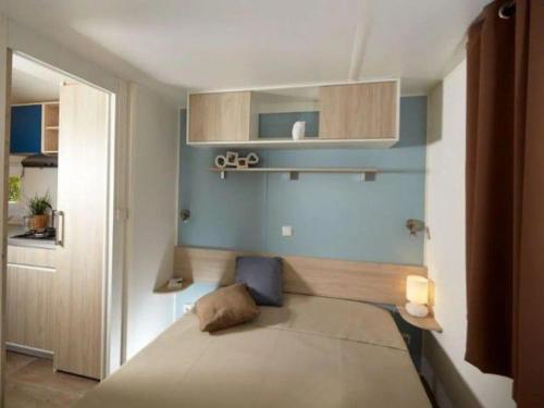 滨海布朗Mobil-home spacieux avec terrasse - 3 chambres - 6 personnes - API-1-52-452的一间带床和蓝色墙壁的卧室