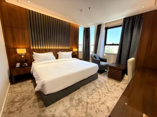 a hotel room with a large bed and a chair at wafia hotel in Al Ḩāyiţ