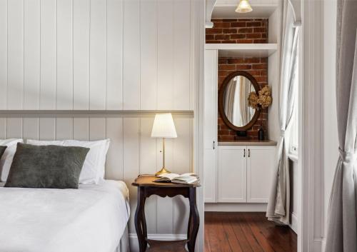 a bedroom with a bed and a table with a lamp at Argyle Hotel, Maclean in Maclean