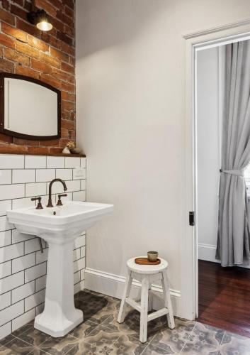 a bathroom with a white sink and a stool at Argyle Hotel, Maclean in Maclean