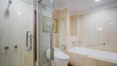 a bathroom with a toilet and a bath tub at Redtop Hotel & Convention Center in Jakarta