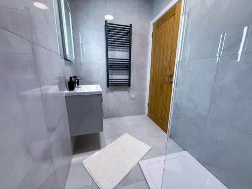 a white bathroom with a sink and a shower at Elegant 1 bed flat, Sleeps 4, Free parking, Pet friendly, Pudsey, Leeds in Pudsey