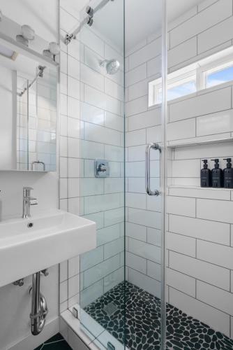 a bathroom with a sink and a glass shower at Renovated 3BR House with Heated Pool and Backyard Oasis in San Diego