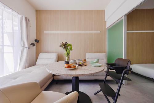 a living room with a table and a couch at Rintow Nagoya Takaoka STAY in Nagoya